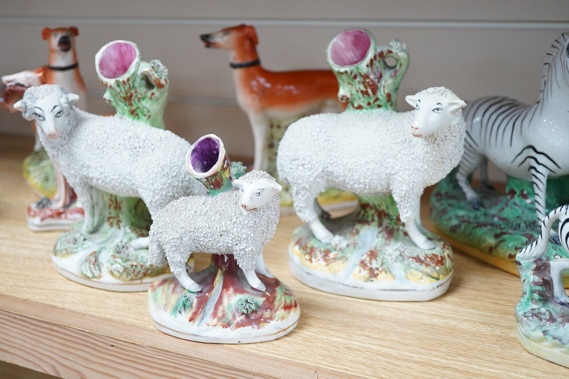 Two pairs of Victorian Staffordshire zebra models and others to include three sheep spill vases, largest 19cm high